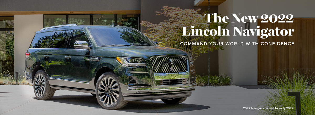 A 2022 Lincoln Navigator is parked in front of a mid-century modern home on a sunny day