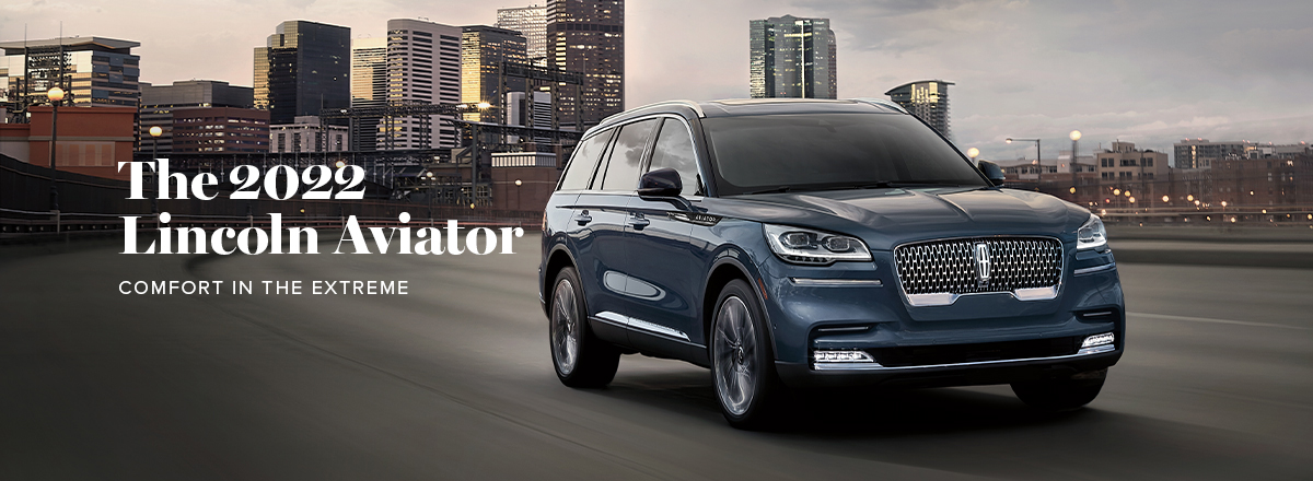 A 2022 Lincoln® Aviator Black Label is shown being driven in front of a city skyline