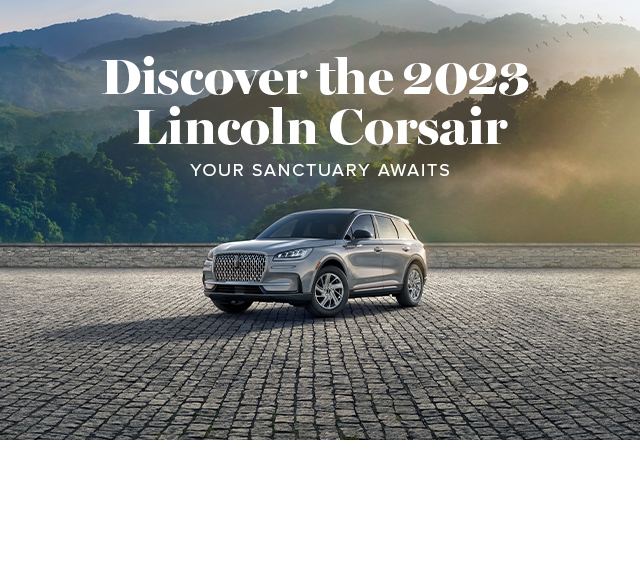 A 2023 Lincoln Corsair in Silver Radiance is parked by a forest overlook.