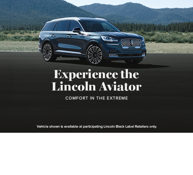 A Lincoln® Aviator Black Label is shown being driven in front of a city skyline